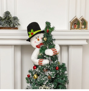 Detailed view of plush snowman Christmas tree topper hugging the evergreen tree