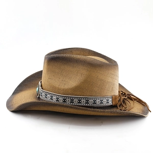 Detail of straw cowboy hat with ethnic patterned band and turquoise stone ornament