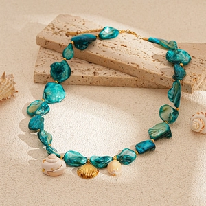 Detail of bohemian necklace with blue shell pieces and golden metal starfish pendant