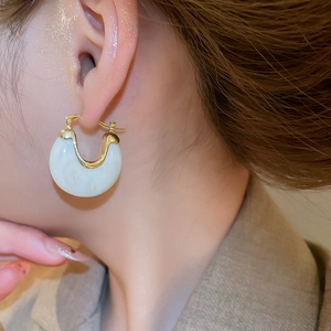 Gros plan de boucles d'oreilles rétro françaises en résine blanc crème et métal doré