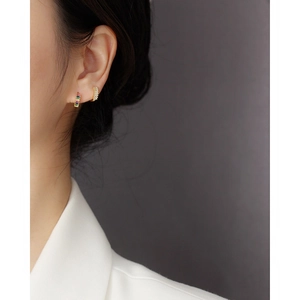 Macro side view of model wearing gold silver earrings with cubic zirconia stones
