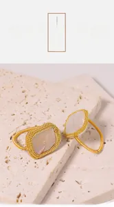 Detail of gold woven rings featuring irregular white mother of pearl with iridescent luster