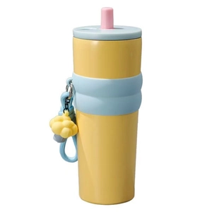Yellow stainless steel insulated tumbler with blue silicone sleeve and straw strap