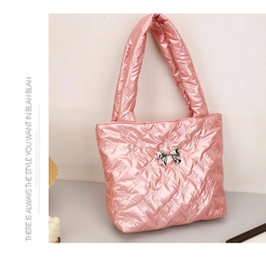 Close-up of pink metallic quilted handbag with silver bow detail and butterfly stitching