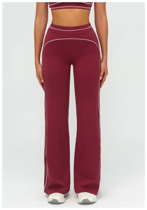 Detail of high-waisted burgundy flared yoga pants with contrast white stitching seams