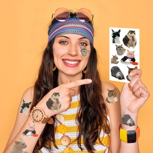 Smiling model showing cute cartoon cat temporary tattoos on arm with orange background