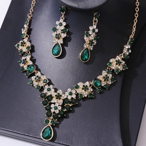 Detail of bridal jewelry set with emerald green crystals and sparkling floral rhinestones