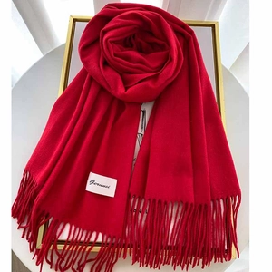 Detailed view of red solid cashmere-feel scarf with tassels in a decorative gold frame