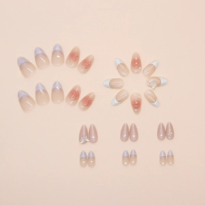 Detail of pink gradient press-on nails with 3D butterfly, pearls and French tips