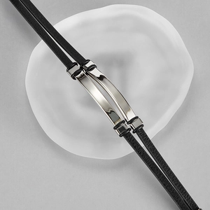 Detail of a black double-layer leather bracelet with polished silver metal nameplates