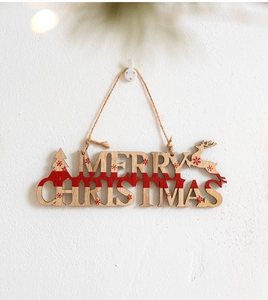 Detail of a wooden Merry Christmas hanging sign with red stripes and rustic hemp rope