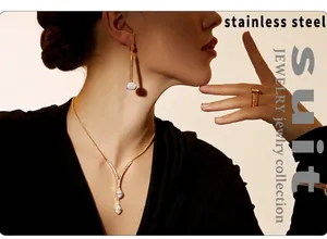 Close-up of gold stainless steel jewelry set including necklace earrings and ring