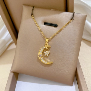 Détail du pendentif étoile et lune en zircon sur collier en acier titane doré en boîte