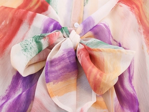 Détail d'une robe sans manches montrant un col à nouer et un imprimé aquarelle coloré
