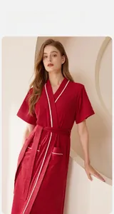 Dettaglio dell'accappatoio assorbente rosso con bordino bianco e cintura in vita coordinata