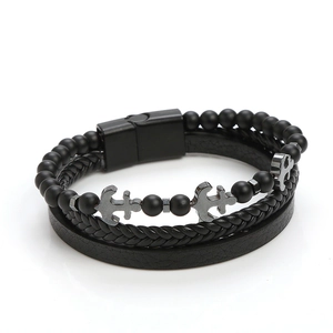 Detail of multi-layer leather bracelet with matte black beads and metal anchor charm