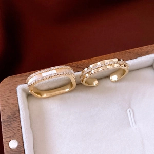 Detail of 14K gold plated rings with shell inlay and diamonds in a jewelry box