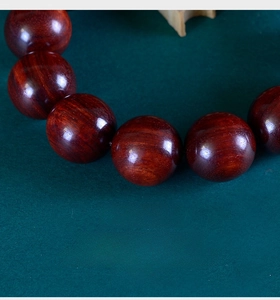 Macro shot of sandalwood prayer beads showing smooth texture and vertical wood grain