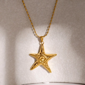 Detailed view of 18k gold starfish pendant necklace with spiral texture on beaded chain