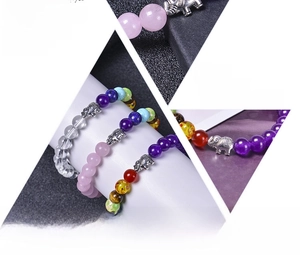 Macro detail of natural stone beaded yoga bracelets featuring a silver elephant charm