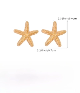 Detailed macro view of large gold starfish earrings with textured zinc alloy finish