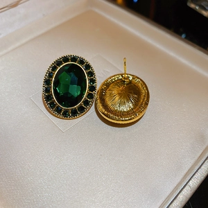 Détail de la boucle d'oreille ovale émeraude vintage avec finition dorée et dos brossé