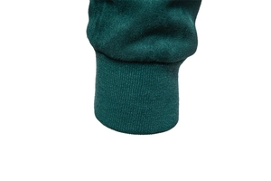 Détail du poignet d'une veste en daim vert foncé avec ourlet côtelé et coutures fines