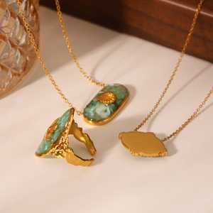 Detail of gold starfish jewelry set with green resin marble and crushed shell inlay
