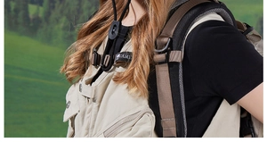 Close-up of beige outdoor vest with metal hardware and black backpack with mesh straps