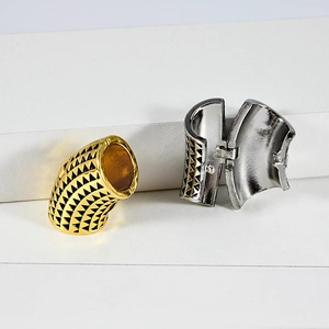 Detail of metal hinge clasp with gold and silver triangle textured geometric patterns