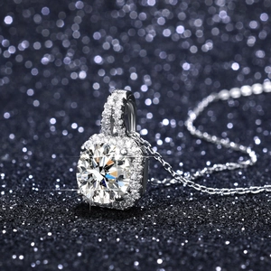 Macro shot of a brilliant-cut halo moissanite pendant necklace on a shimmering background