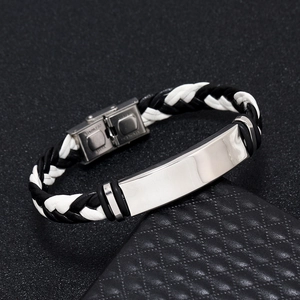 Macro shot of bicolor braided leather bracelet with engraved stainless steel clasp