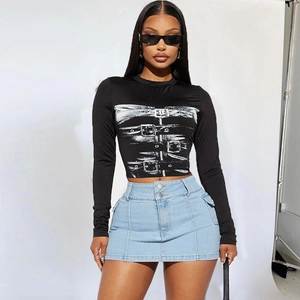 Detail of slim fit black long sleeve crop top with print and high waist denim mini skirt