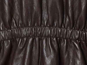 Detail der dunkelbraunen Kunstlederjacke mit elastischer Taille und feiner Narbung