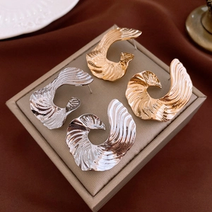 Abstract metal swirl earrings in gold and silver finish with striped geometric texture