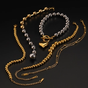 Detailed view of stainless steel beaded chains with heart charms in gold and silver finish