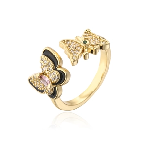 Detailed shot of golden butterfly ring with black enamel and colorful zircons