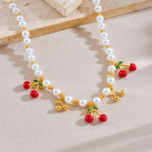 Choker élégant en perles blanches et dorées avec pendentifs cerises rouges sur pierre