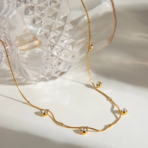 Elegante vergoldete Edelstahlkette mit runden Zirkonia-Anhängern und kleinen Perlen