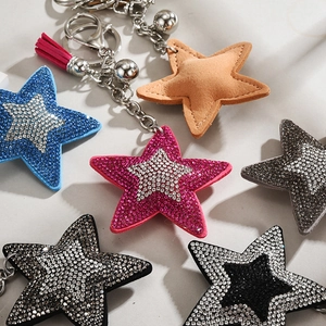 Close-up of sparkling sequin star keychains with metallic tassels and colorful bells