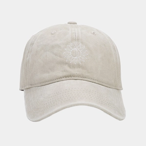 Détail de la broderie soleil et texture en coton lavé sur casquette beige vintage