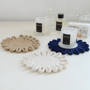 Detailed close-up of woven flower-shaped cotton coasters in beige, blue, and cream white
