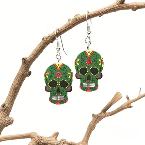 Detail of green acrylic sugar skull earrings with floral relief on a branch