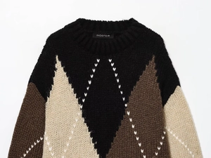 Close-up of diamond pattern knit texture and brand label on thick crewneck sweater