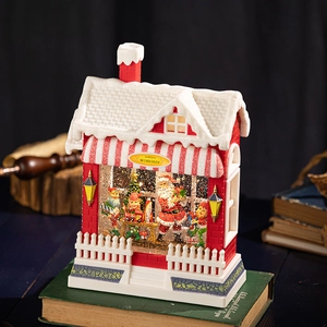 Illuminated Santa's Workshop snow globe house with glittering lights and festive scenery