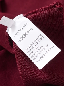 Detail shot of garment wash label showing 100% polyester fabric and care instructions