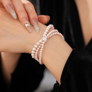 Close-up of a three-row pearl bracelet with a luxury rectangular diamond-encrusted clasp