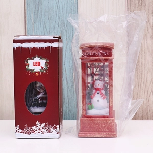 Close-up of a red Christmas telephone booth LED light with snowman inside and gift box