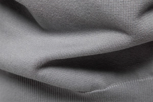 Close-up of gray knit fabric showing the detailed texture and woven structure of a cardigan