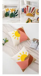 Detail of bohemian tufted embroidery cushion cover with abstract sun and mountain patterns